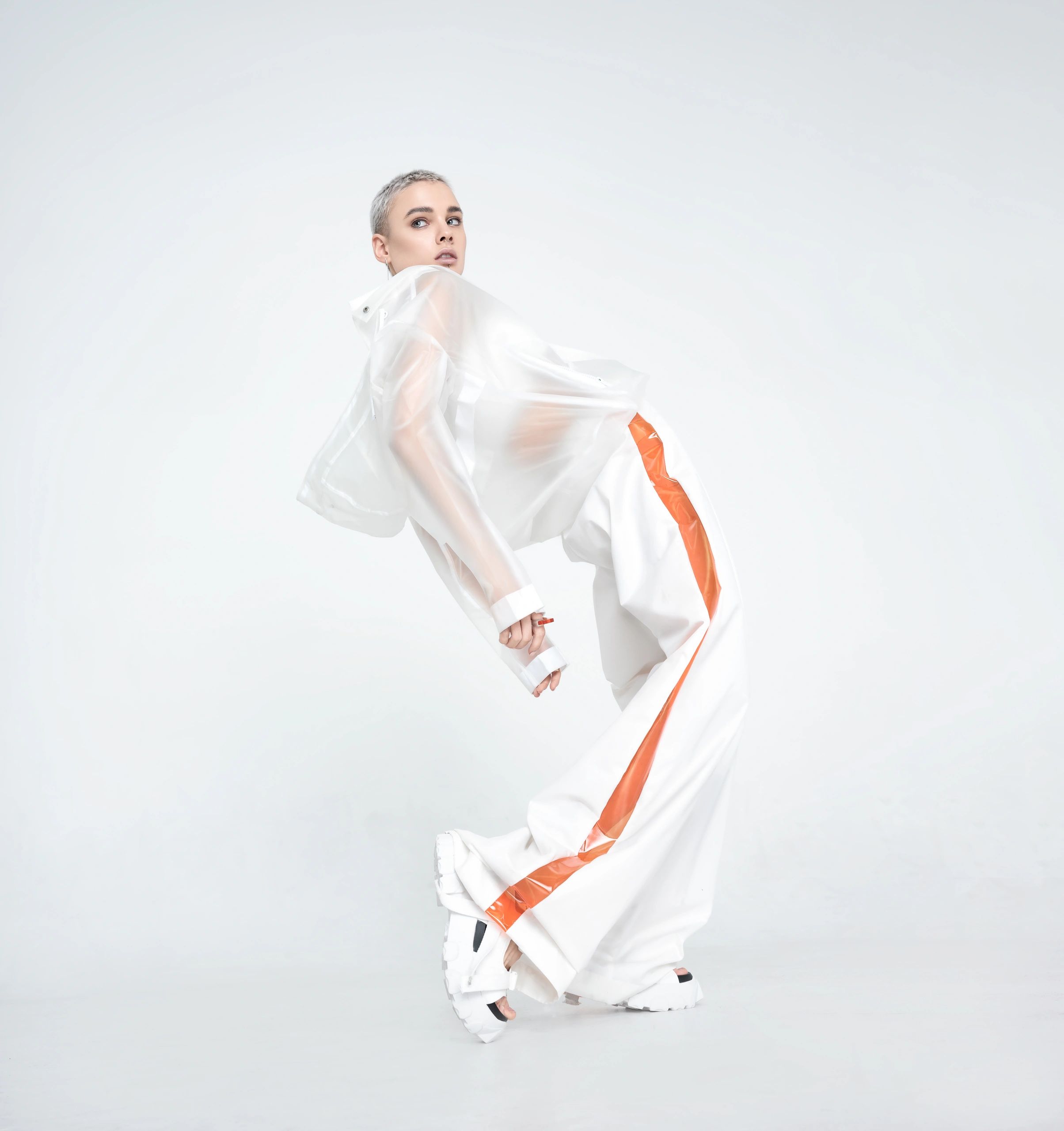 Fashion model in a futuristic editorial pose against white background