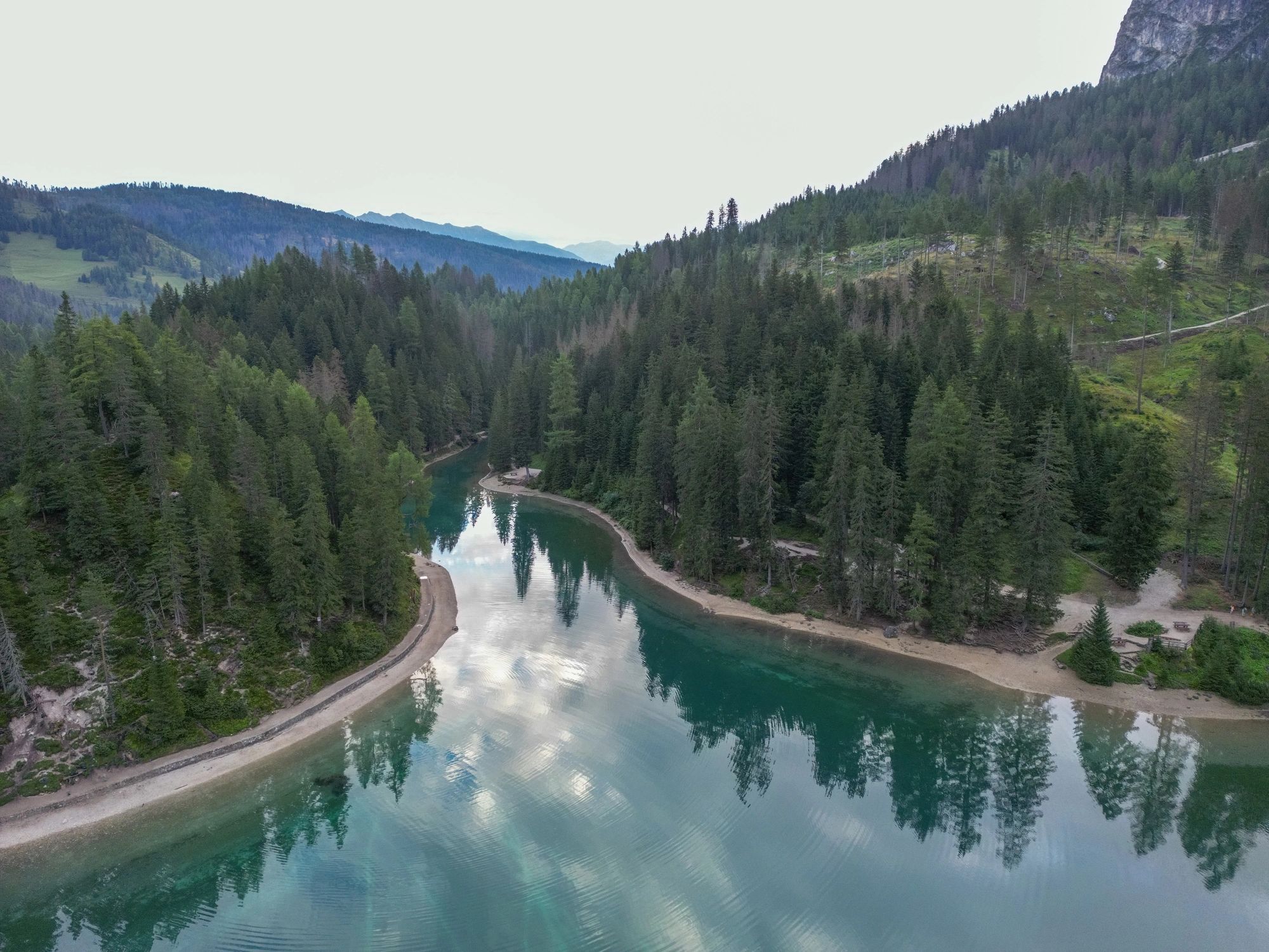 Serene lake surrounded by dense forest from above
